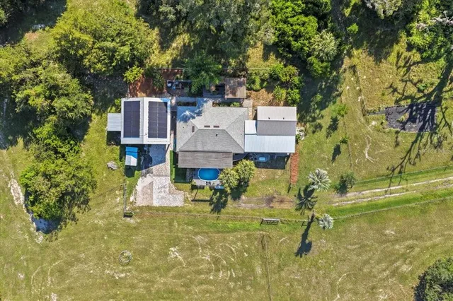 aerial view of a house with a yard basket ball court and outdoor seating