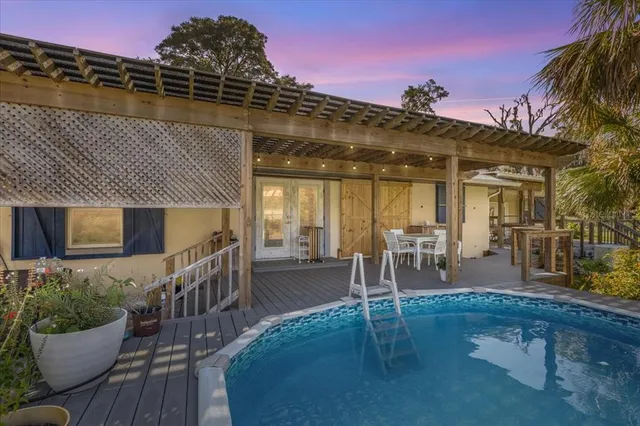 a view of a patio with table and chairs potted plants with wooden floor and seating space