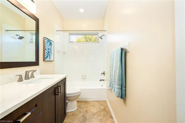 a bathroom with a granite countertop sink a toilet a mirror a vanity and shower