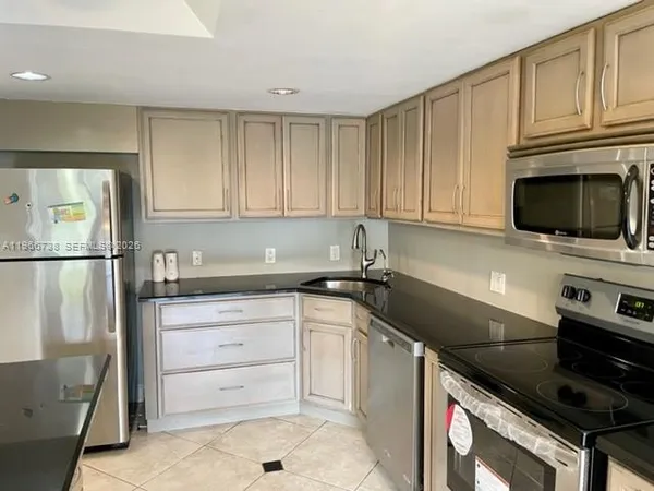 a kitchen with granite countertop cabinets stainless steel appliances and a counter space