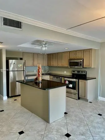 a kitchen with stainless steel appliances granite countertop a sink a stove a refrigerator and cabinets