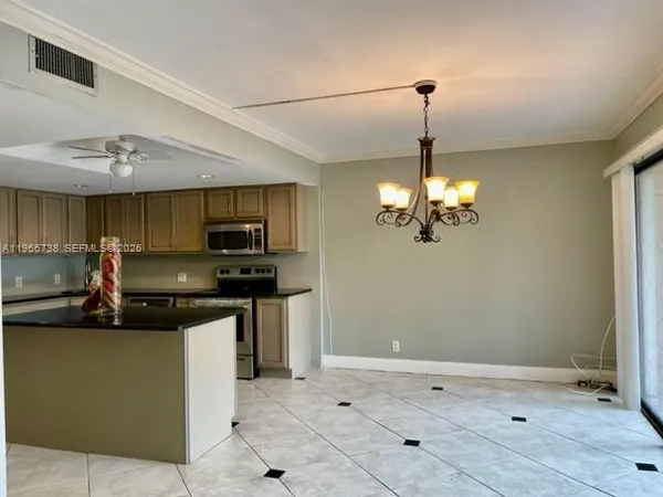 a kitchen with kitchen island granite countertop a sink cabinets and stainless steel appliances