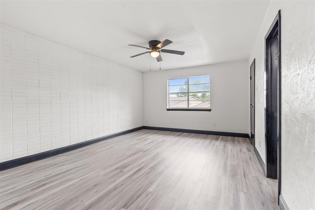 2802 Spring Valley Drive Bedford, TX 76021 - Photo 14 of 24 an empty room with wooden floor ceiling fan and windows