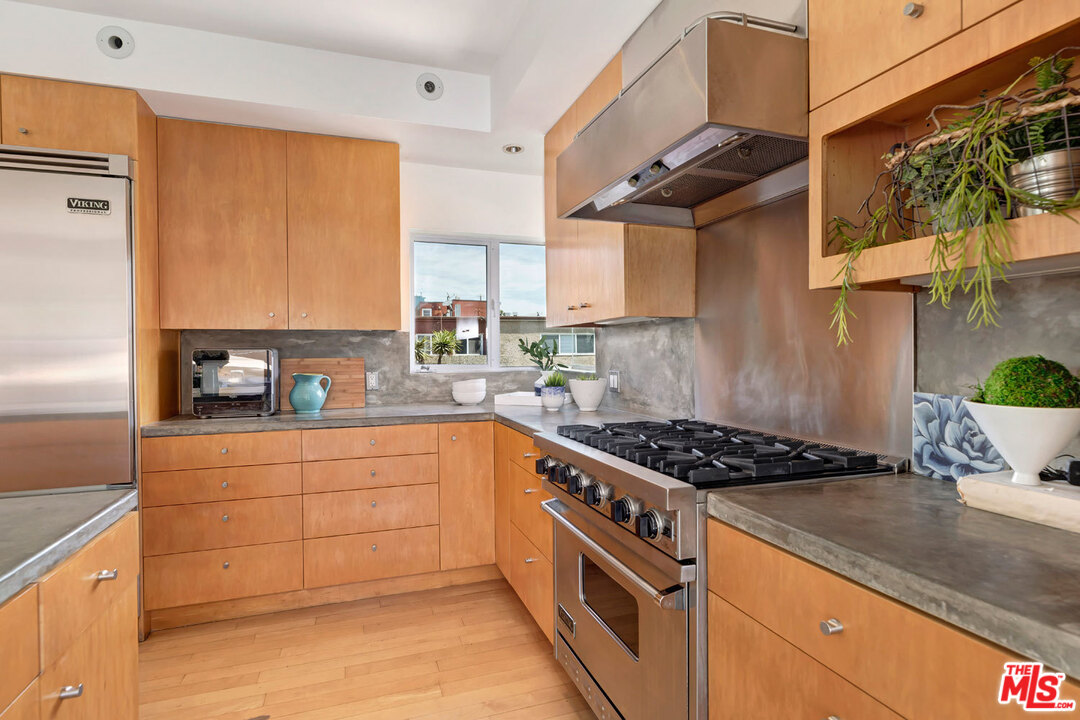 32 Fleet Street Marina del Rey, CA 90292 - Photo 11 of 39 a kitchen with stainless steel appliances granite countertop a sink stove and cabinets