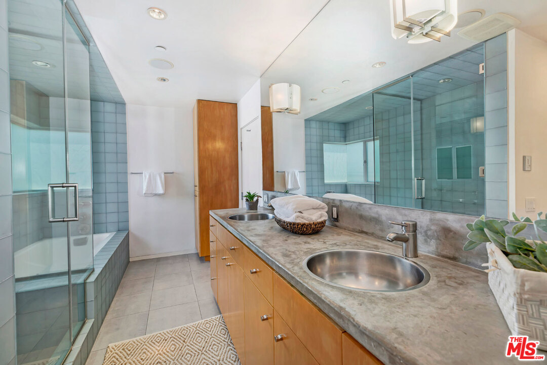 32 Fleet Street Marina del Rey, CA 90292 - Photo 18 of 39 a bathroom with a granite countertop sink a mirror and shower