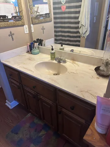a bathroom with a granite countertop sink and a mirror