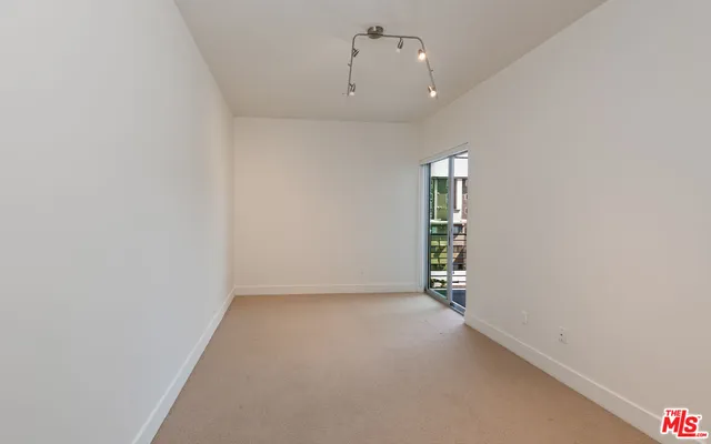 an empty room with closet and a hallway