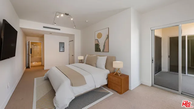 a spacious bedroom with a bed and glass door