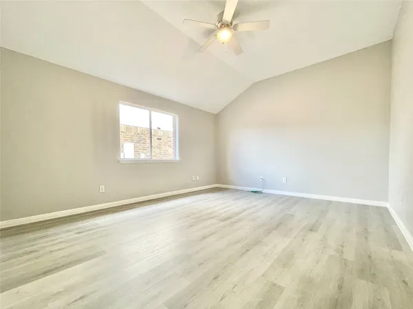 an empty room with a window and a ceiling fan