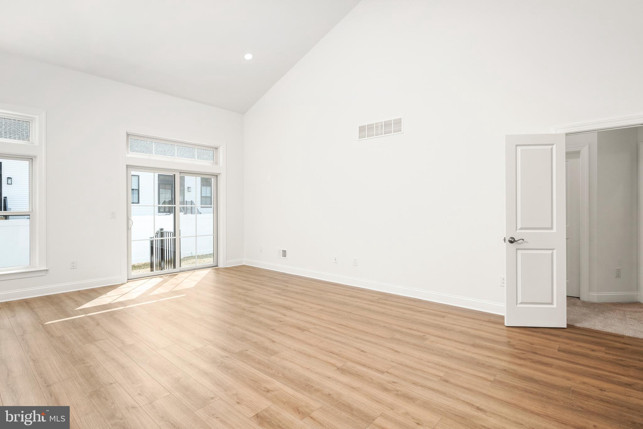 55 Kay Chiarello Way Hamilton, NJ 08690 - Photo 7 of 49 a view of an empty room with wooden floor and windows