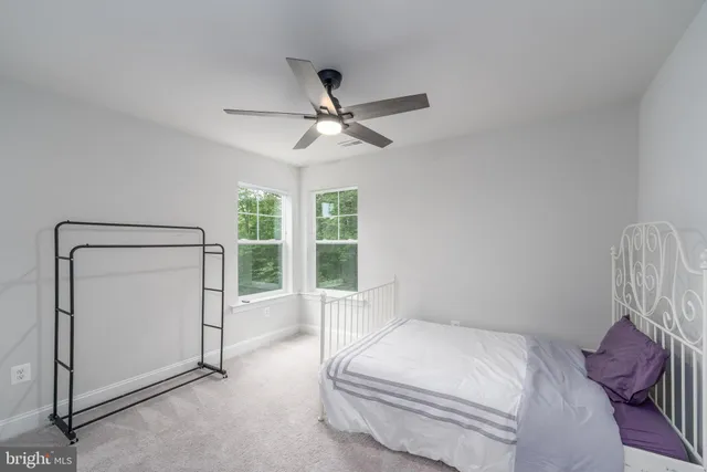 a bedroom with a large bed and a ceiling fan
