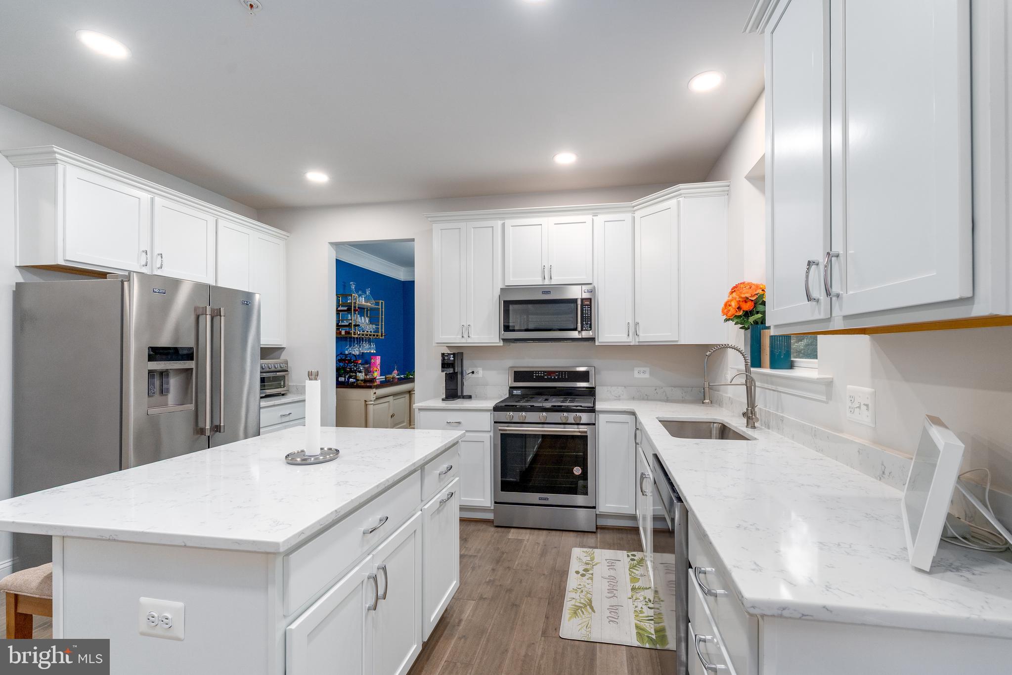 6210 Hunters Hollow Road Elkridge, MD 21075 - Photo 5 of 41 a kitchen with a sink a stove a refrigerator and white cabinets