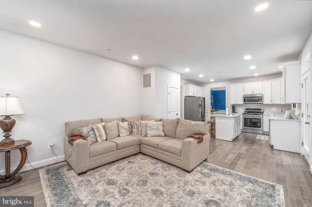 a living room with furniture and view of kitchen