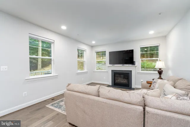 a living room with furniture a fireplace and a flat screen tv