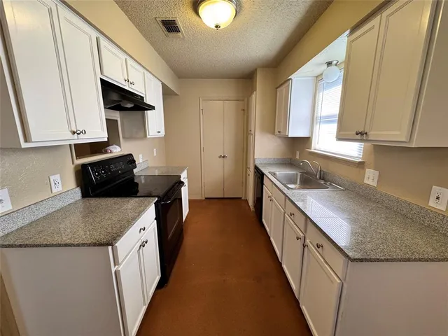 a kitchen with granite countertop sink and cabinets