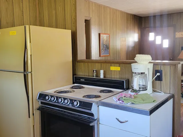 a kitchen with kitchen island a stove a refrigerator and a sink
