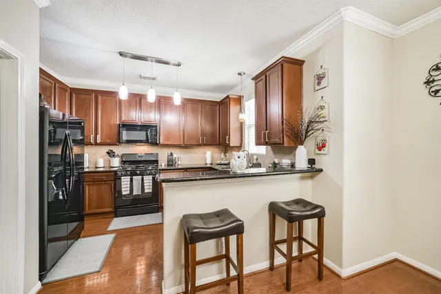 a kitchen with stainless steel appliances granite countertop a sink stove microwave and cabinets