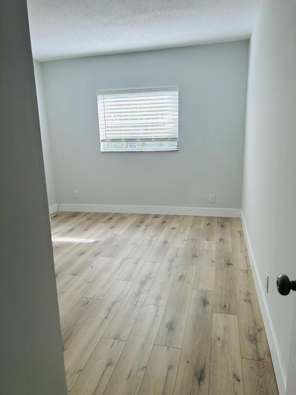 260 Northwest 19th Street, Unit 6 Boca Raton, FL 33432 - Photo 6 of 11 an empty room with wooden floor and windows
