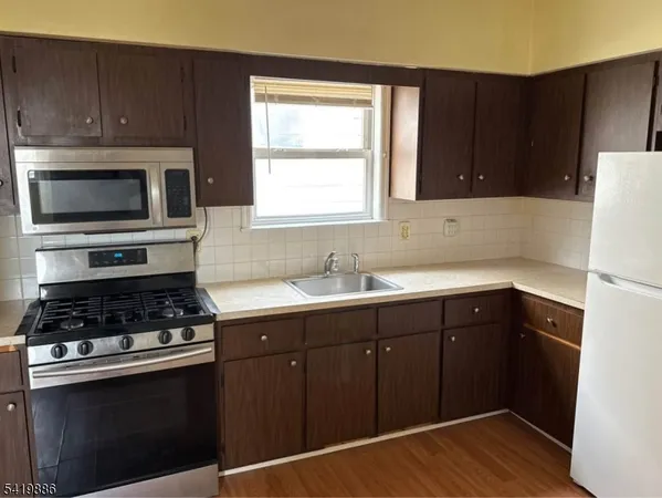 a kitchen with a sink cabinets stainless steel appliances and a window