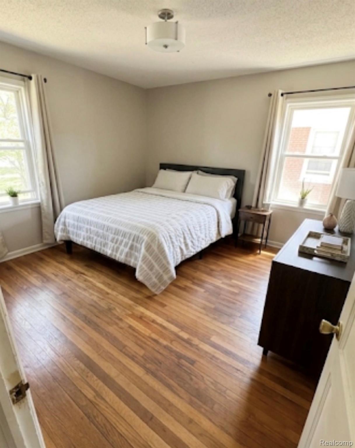 18418 Edinborough Road Detroit, MI 48219 - Photo 11 of 25 Bedroom with multiple windows, hardwood / wood-style floors, and a textured ceiling