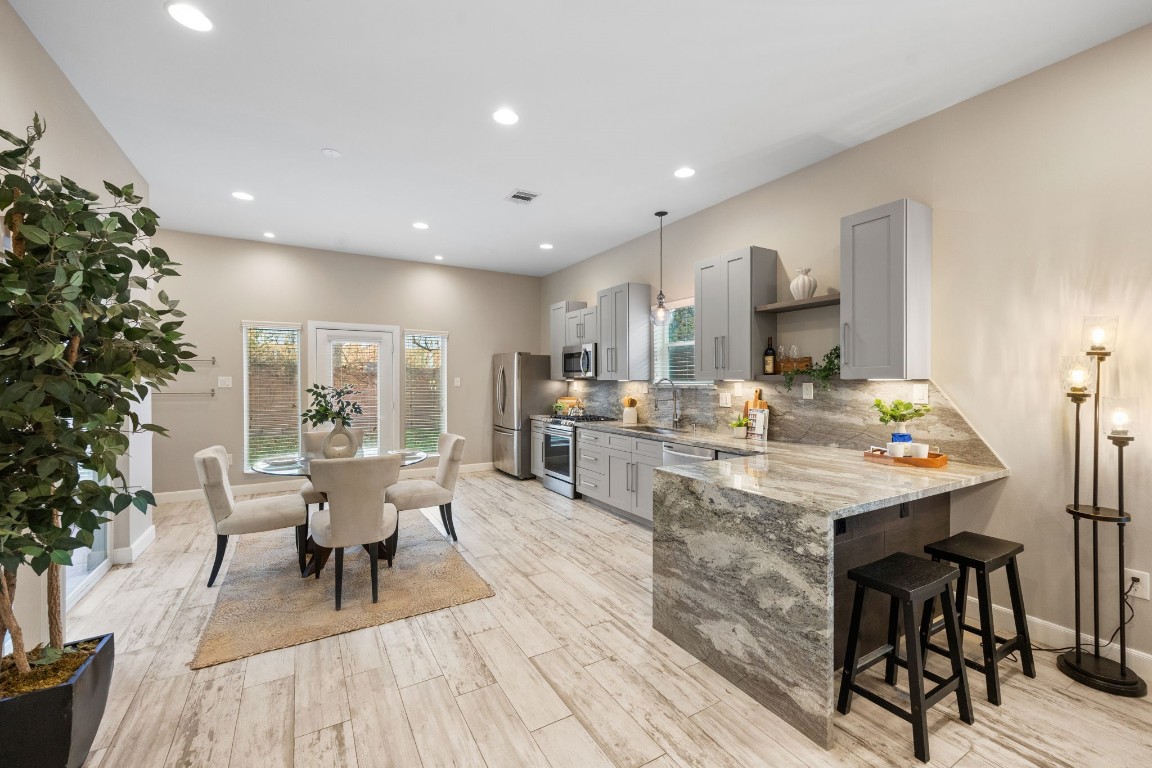 317 East 35th Street, Unit A Houston, TX 77018 - Photo 1 of 24 Open-concept kitchen and dining area featuring granite countertops, stainless steel appliances and ample cabinetry designed for both everyday living and entertaining.