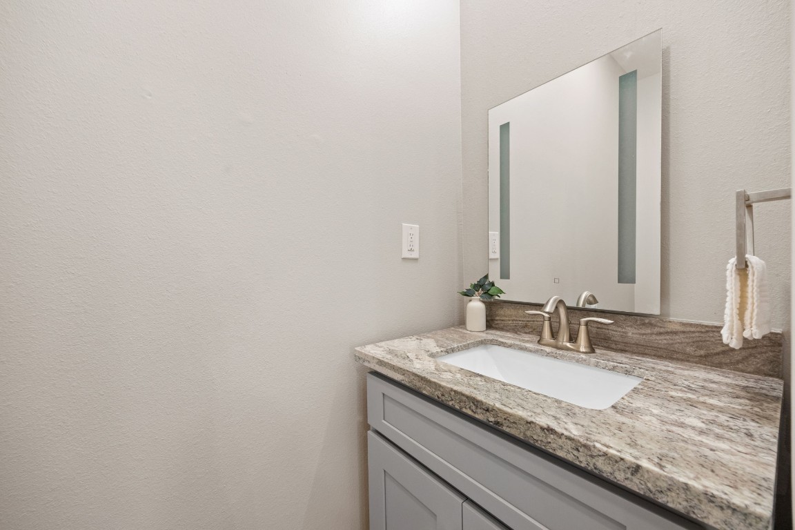 317 East 35th Street, Unit A Houston, TX 77018 - Photo 12 of 24 a bathroom with a granite countertop sink and a mirror