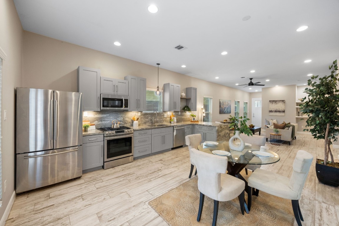 317 East 35th Street, Unit A Houston, TX 77018 - Photo 7 of 24 a kitchen with a refrigerator and a dining table