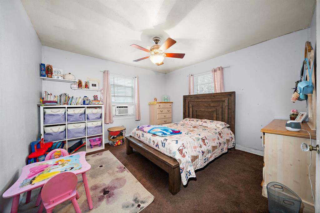 2119 Alexander Avenue Waco, TX 76708 - Photo 13 of 20 a bedroom with a bed and a chandelier