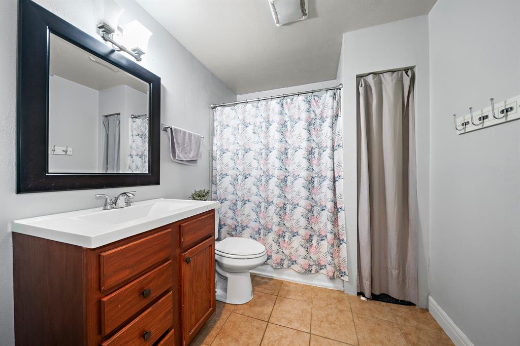 2119 Alexander Avenue Waco, TX 76708 - Photo 14 of 20 a bathroom with a sink toilet and mirror