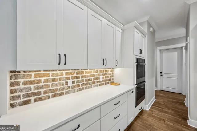 a view of a hallway with a sink and mirror