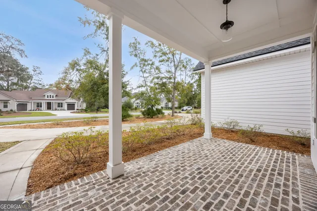 a large white kitchen with a stove a sink dishwasher a dining table and chairs with wooden floor