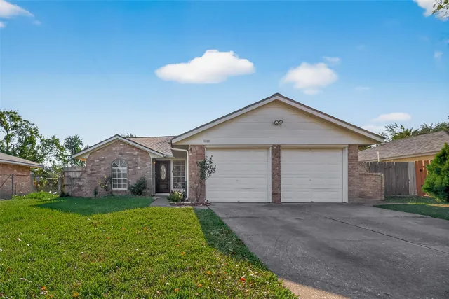 a view of a house with a yard and large tree