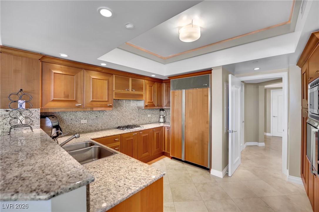 2777 Paradise Road, Unit 1803 Las Vegas, NV 89109 - Photo 11 of 48 Kitchen featuring light stone countertops, tasteful backsplash, appliances with stainless steel finishes, a raised ceiling, and recessed lighting