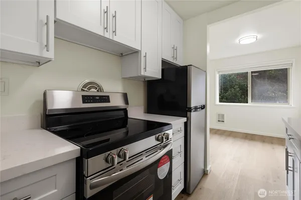a kitchen with stainless steel appliances a sink dishwasher and cabinets with wooden floor