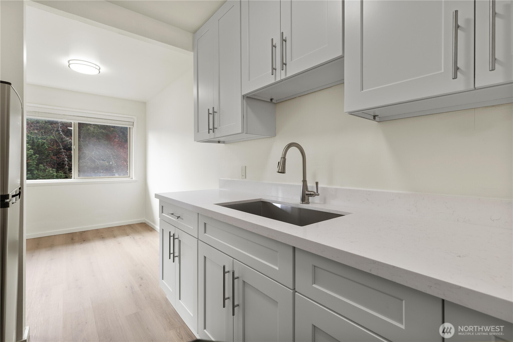 2614 Rucker Avenue Everett, WA 98201 - Photo 14 of 17 a kitchen with stainless steel appliances a sink dishwasher and cabinets with wooden floor