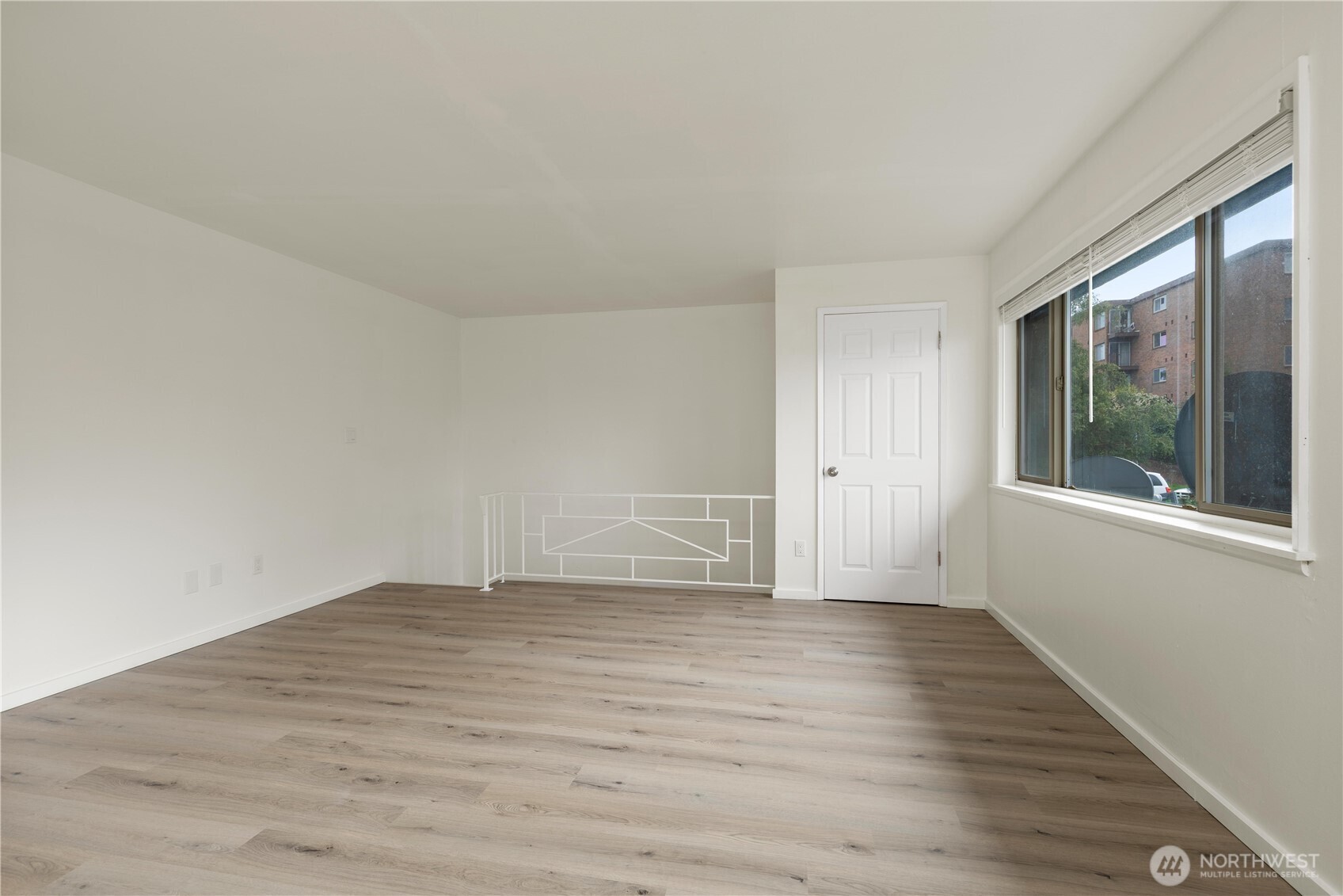 2614 Rucker Avenue Everett, WA 98201 - Photo 8 of 17 a view of an empty room with wooden floor and a window