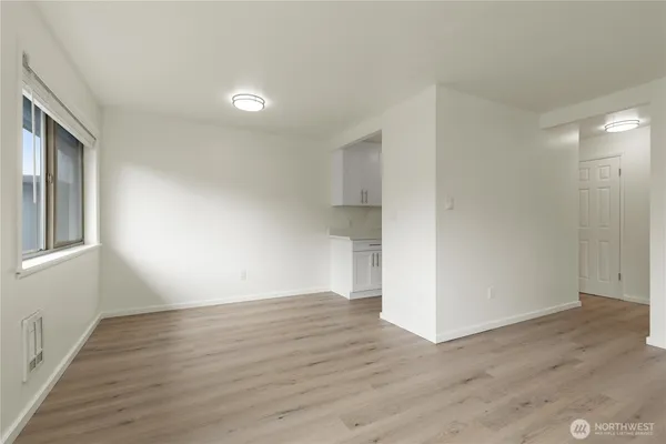 a view of a kitchen with wooden floor and electronic appliances