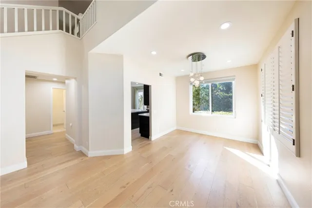 a view of empty room with wooden floor and windows
