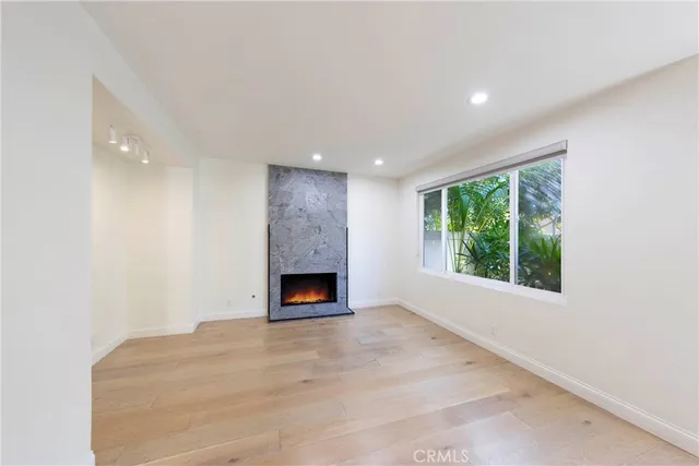 a view of an empty room with a fireplace and a window
