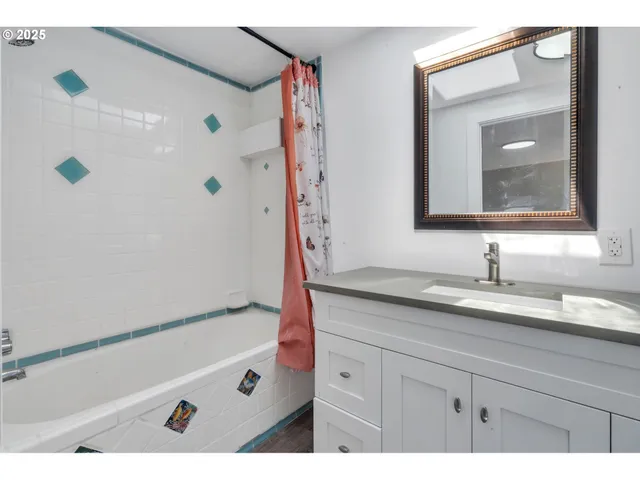 a bathroom with a granite countertop sink a mirror a vanity a shower and a bathtub