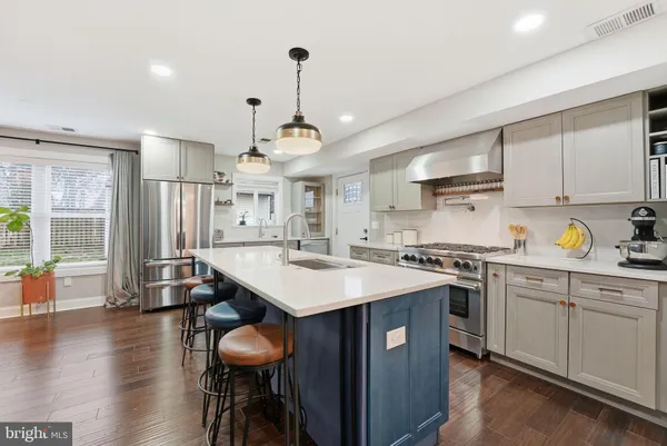 a kitchen with granite countertop a table chairs stove and white cabinets