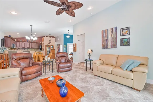 a living room with furniture kitchen view and a chandelier