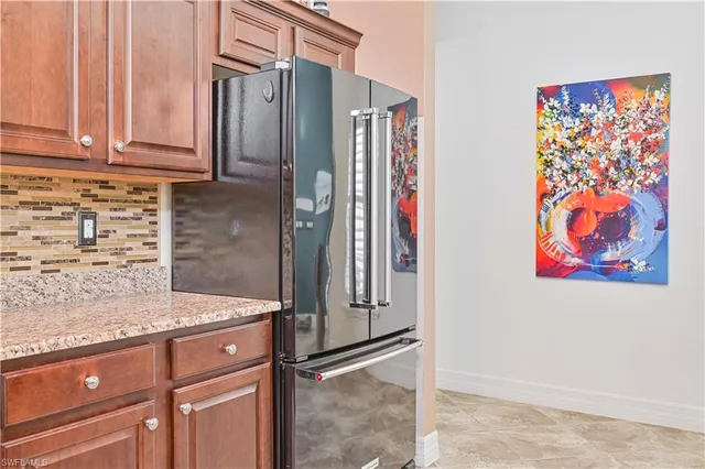 a kitchen with stainless steel appliances granite countertop a refrigerator and a sink