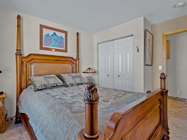 a bedroom with a bed and painting on the wall