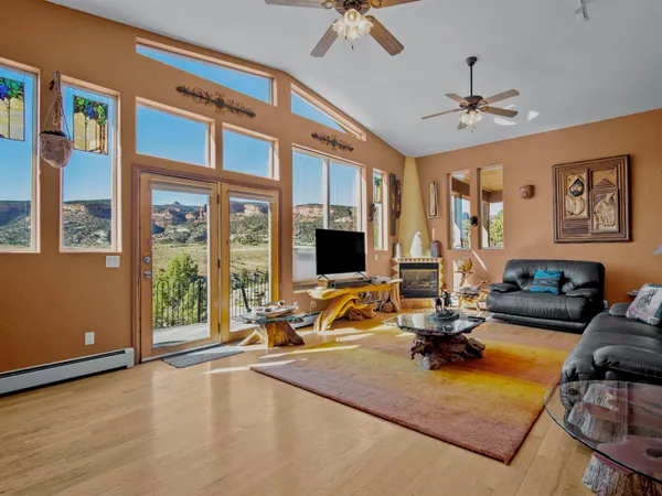 a view of a livingroom with furniture hardwood floor and a ceiling fan