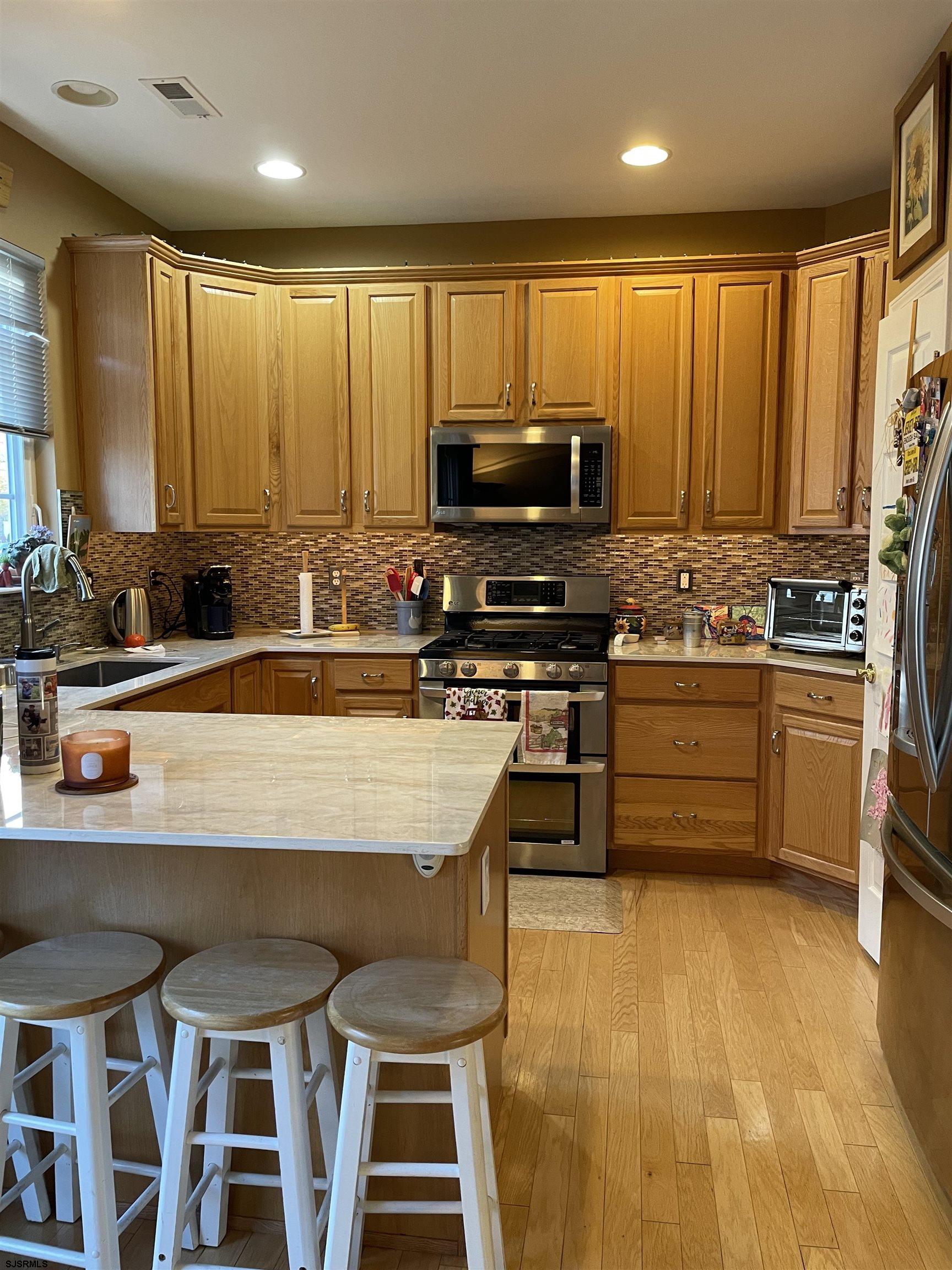 68 Ables Run Drive Absecon, NJ 08201 - Photo 6 of 28 a kitchen with stainless steel appliances a stove a sink a microwave a refrigerator and cabinets