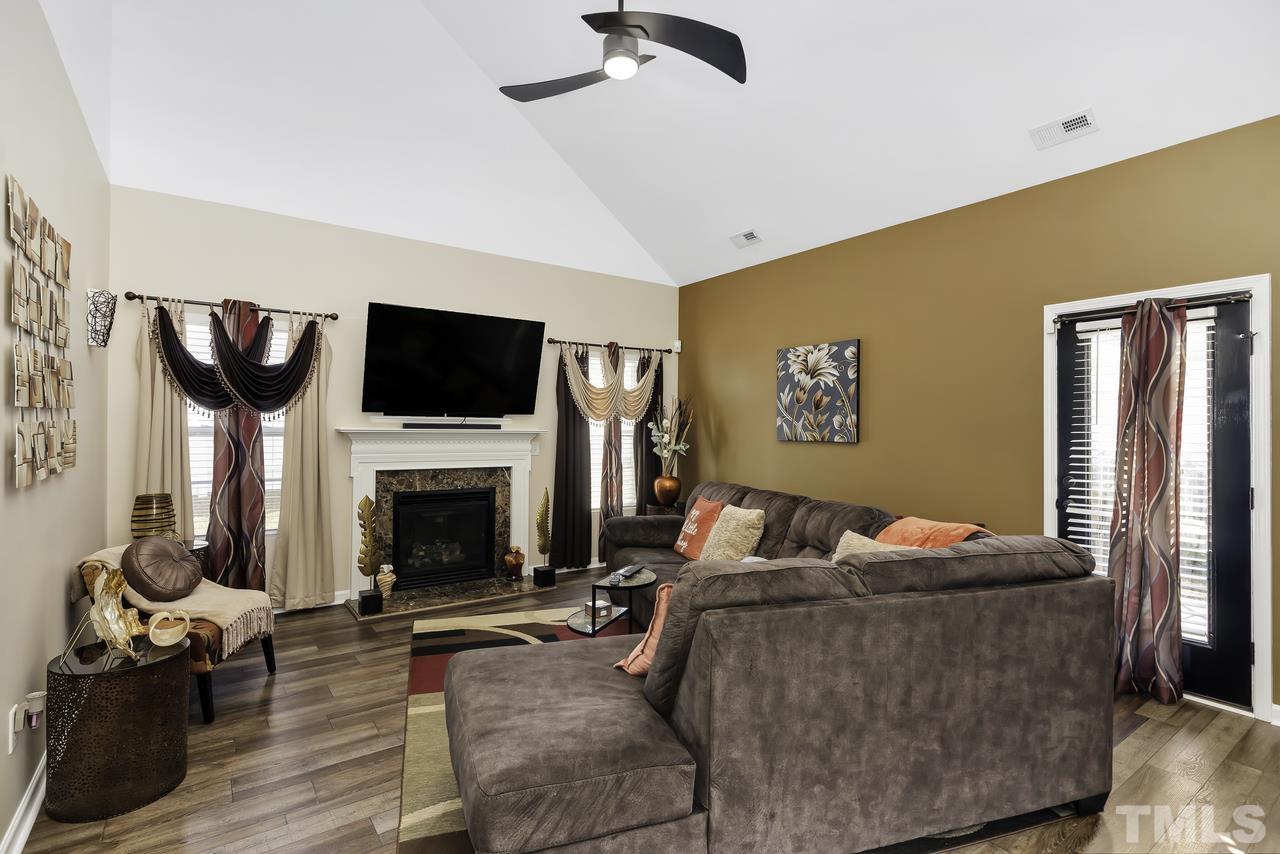 4704 Jelynn Street Raleigh, NC 27616 - Photo 12 of 30 a living room with furniture a fireplace and a flat screen tv