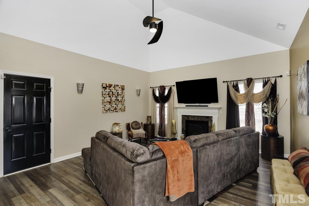 4704 Jelynn Street Raleigh, NC 27616 - Photo 13 of 30 a living room with furniture a flat screen tv and a fireplace