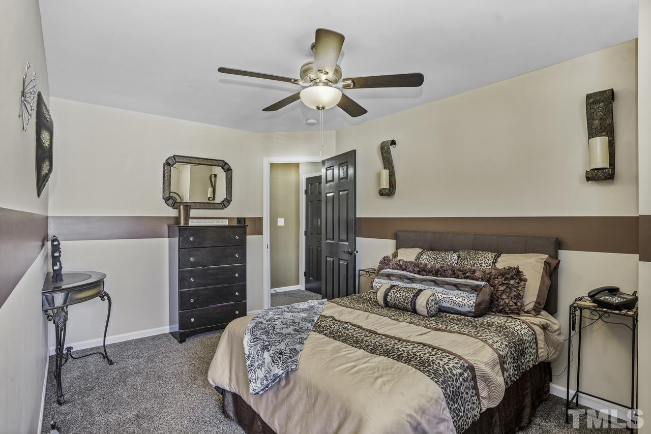 4704 Jelynn Street Raleigh, NC 27616 - Photo 20 of 30 a bedroom with a bed and a chandelier