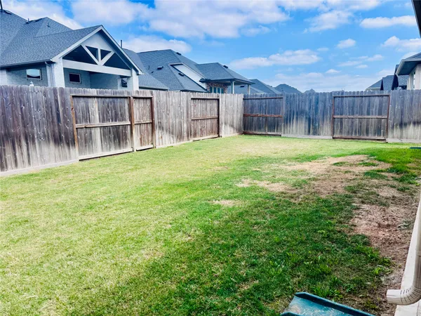 a view of a backyard with a small cabin and wooden fence